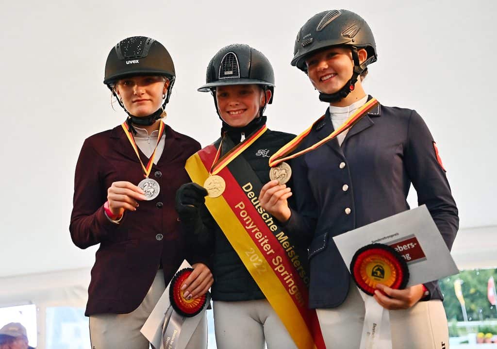 Drei junge Damen holten die DJM-Medaillen in der Pony-Meisterschaft Springen, v.l. Lenie Pander (Silber), Jolie Marie Kühner (Gold) und Carlotta Merschformann (Bronze). (Foto: Pferdefotografie Mihsen)